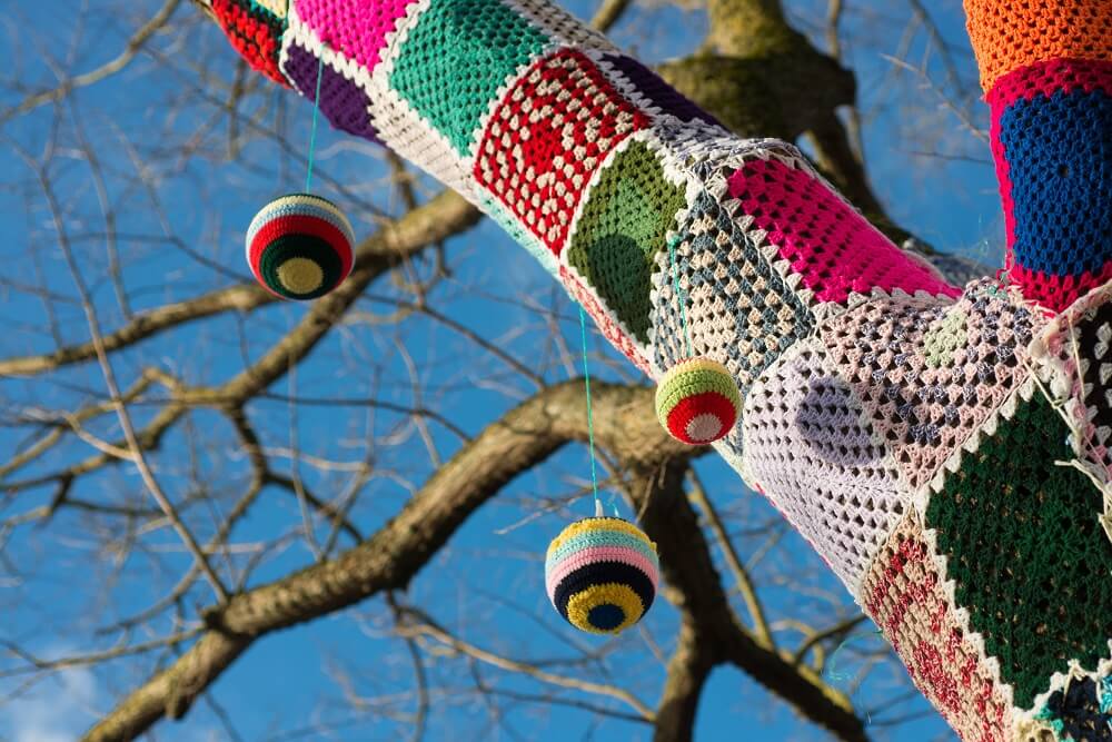 yarn bombing on a tree with blue sky